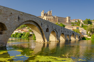 Obraz premium Pont Vieux- A bridge spans a river with a castle in the background