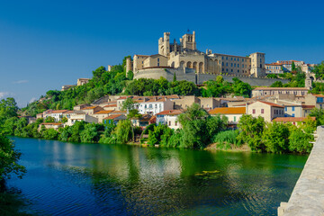 Fototapeta premium Cathedral Saint-Nazaire-A river runs through a town with a castle in the background
