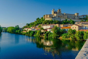 Cathedral Saint-Nazaire-A river runs through a town with a castle in the background