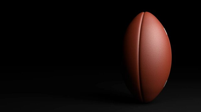 Rotating American football ball on a black background, Seamless Loop video