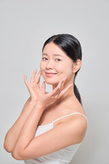 Asian female model with confident expression touching her face with both hands. Korean cosmetics female model.