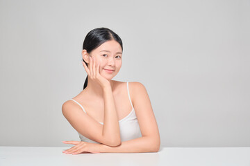 A female cosmetics model with a confident expression touching her clear and clean skin. Korean female model.