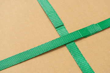close up of green packaging plastic belt from the cardboard box that shows the connection point