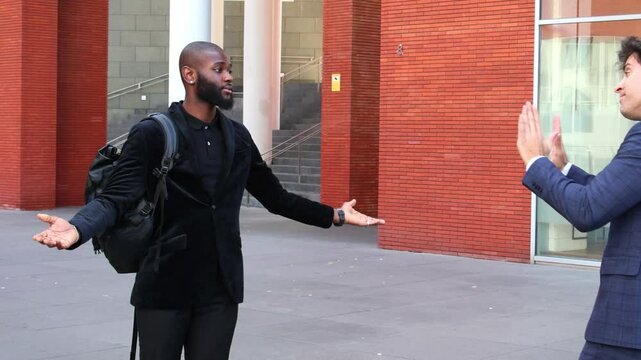 black African businessman scolds Hispanic colleague for arriving late to work meeting outside office