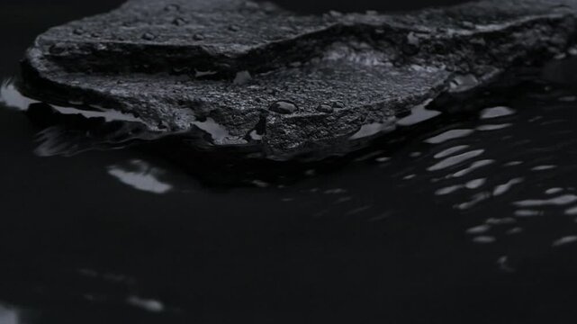 Slow motion water surface texture splashes, waves and ripples with black stone