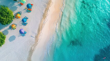 Stunning aerial view of a white sand tropical beach with rows of umbrellas and chairs overlooking the calm blue sea.