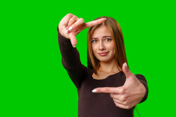 Fototapeta premium Woman Framing With Fingers On Green Screen