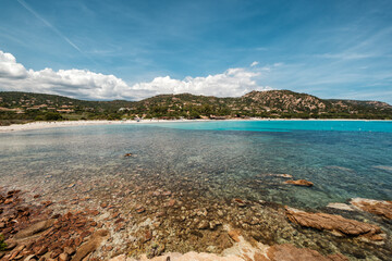 Azure Mediterranean sea gently lapping onto the rocky coastline overlooking Plage de Folaca on the south east coast of the island of Corsica