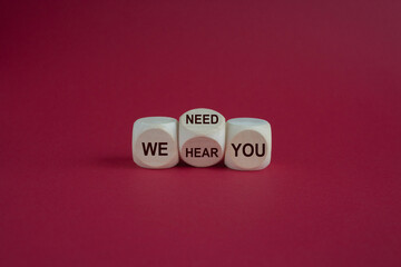 We need and hear you symbol. Turned a wooden cube and changes words we need you to we hear you. Beautiful red background. Business, support we need and hear you concept.