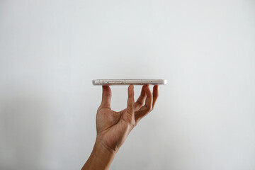 Raised Hands Hoding Smartphone Over White Background