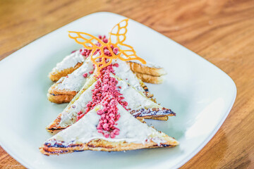 Pancakes with red velvet sauce decorated with butterflies on a plate
