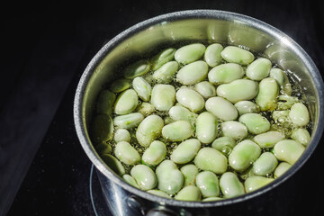 fresh greens broad beans fava boiled on a dark background