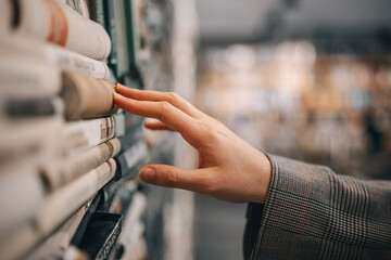 A hand reaches for a book in a dusty bookstore