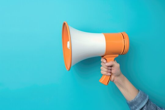 Hand holding a megaphone on blue background