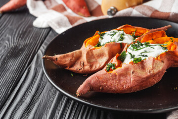baked sweet potatoes on a dark wooden rustic background