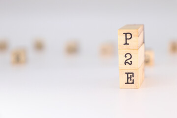 P2E acronym - Concept of Play to Earn written on wooden cubes on white background with copy space.