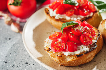 delicious Italian bruschetta with tomatoes on a light stone background