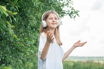 A child  with headphones listening to music and dancing.