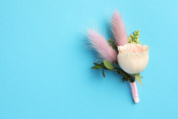 Small stylish boutonniere on light blue background, top view. Space for text © New Africa