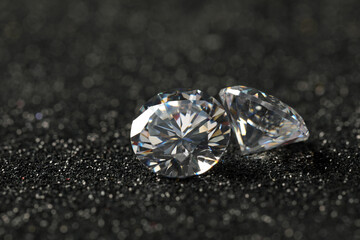 Beautiful dazzling diamonds on dark shiny background, closeup. Space for text