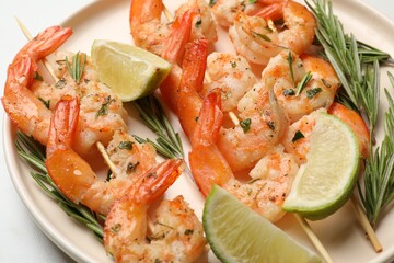 Skewers with delicious grilled shrimps served on plate, closeup