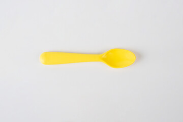 Yellow spoon isolated on white background.