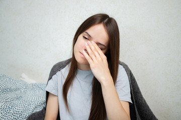 Sick teenager with cold and flu, lying in bed, resting at home, suffering from fever.