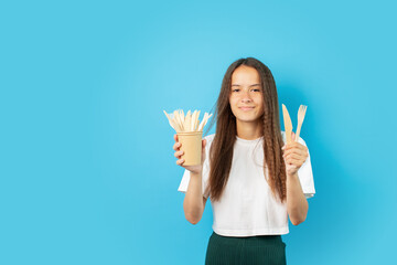 teenager girl with wooden utensils, Bamboo tableware, disposable organic kitchen, reusable use, recyclable waste, outdoor catering