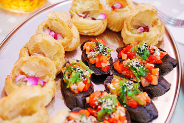 profiteroles and a baguette with vegetables on the banquet table. canapes for a buffet. catering services.