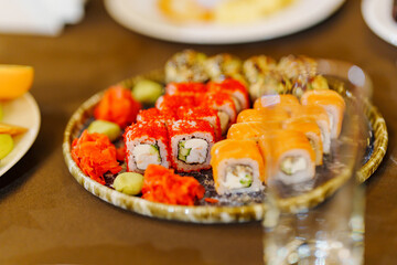 A large plate with rolls. A set of assorted rolls for the holiday. Ordering and delivery of Japanese cuisine.