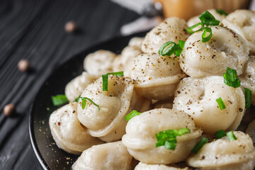 fresh cooked dumplings on a black wooden rustic background