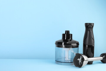 Hand blender kit on light blue background, space for text
