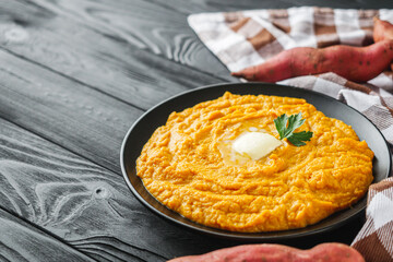 delicious mashed sweet potatoes on a black wooden rustic background