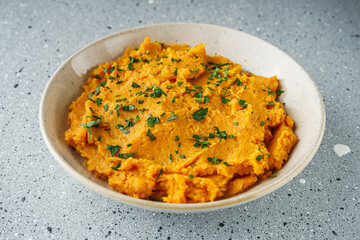 delicious mashed sweet potatoes on a light stone background