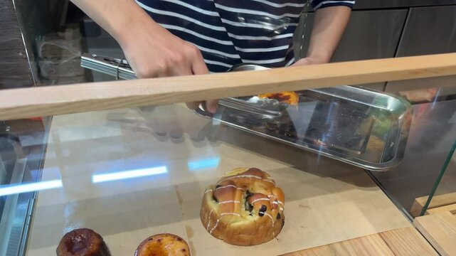 get dessert from the display case shop assistant waiter takes the dessert from the display case and puts the tasty treat on a plate to warm up