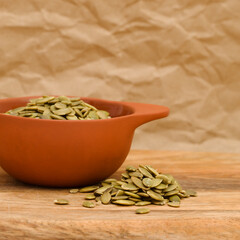Hulled pumpkin seeds on wooden surface