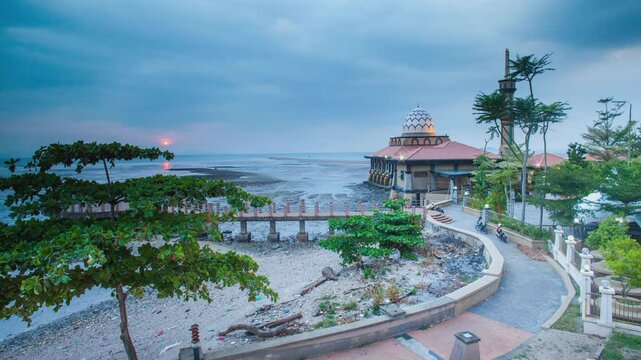 Bright and sunny sunrise time Interval by the sea against the Al-Hussain Mosque in Perlis, Malaysia at dusk.