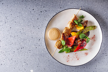 barbecue chicken and vegetables on a white plate