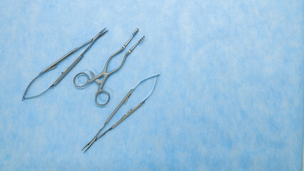 Stainless medical equipment used by surgeons in surgery placed on a blue background. Surgical instruments used in operating room.