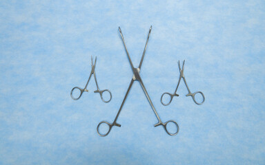 Fototapeta premium Stainless medical equipment used by surgeons in surgery placed on a blue background. Surgical instruments used in operating room.