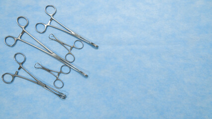 Fototapeta premium Stainless medical equipment used by surgeons in surgery placed on a blue background. Surgical instruments used in operating room.
