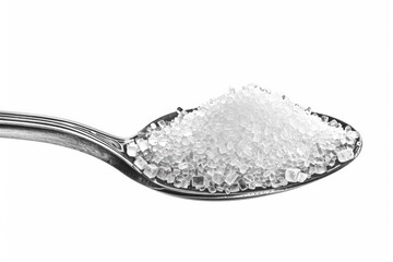 Sugar On Spoon. Silver Spoon with White Sugar Isolated on Kitchen Background