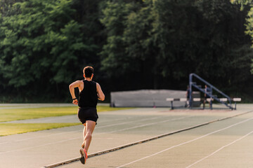 Athlete running on the inside lane of the athletics track during a race