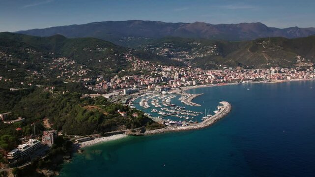 Drone shot circling around the Marina di Varazze of Celle Ligure in the Italian region Liguria with blue sea