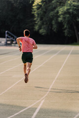 Track runner running alone on the athletics track in the evening