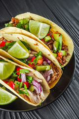 set of delicious juicy tacos on black wooden rustic background