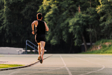 Fototapeta premium Professional athlete training on the town's athletics track in the autumn
