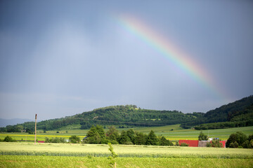 Tęcza nad górami, zielone pola, dachy domów. © Stanisław Błachowicz