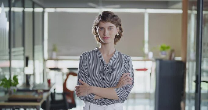 Young adult gen z cute girl agent boss standing proud fold hand look cam indoor job office work place happy french woman lady worker expert staff in formal dress cross arms do pose head shot video day