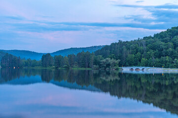 Setting sun low light long exposure over mountain lake summer season background image
